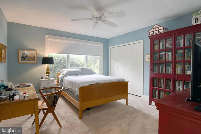 a bedroom with a bed furniture and a book shelf