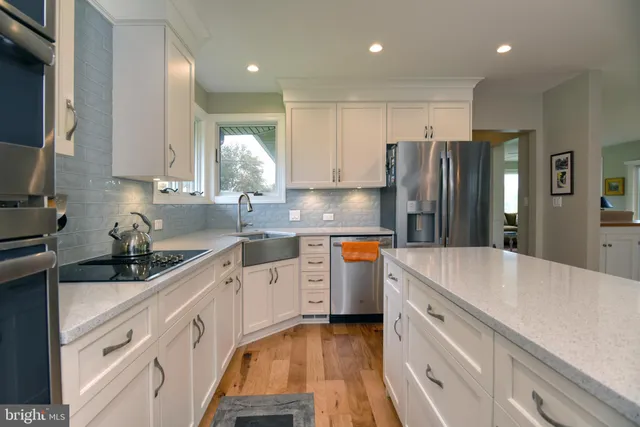 a kitchen with granite countertop a sink stainless steel appliances and cabinets