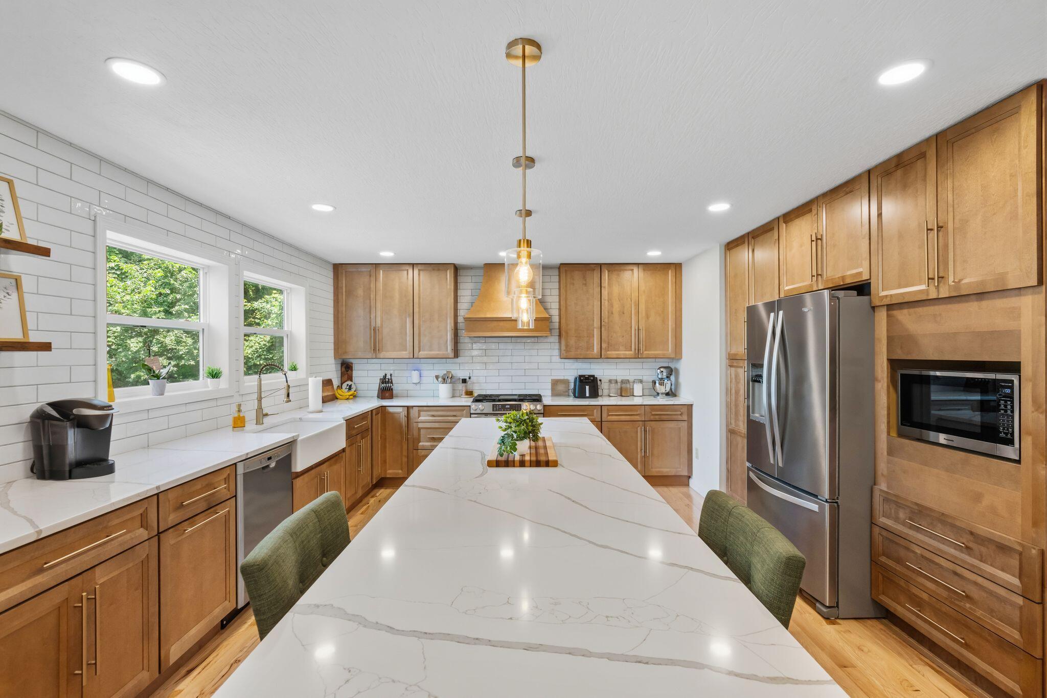 10446 Rich Hollow Road Southwest Lancaster, OH 43130 - Photo 26 of 83 Expansive kitchen island with a white veined countertop, complemented by light wood-finish cabinetry, stainless steel appliances, a white subway tile backsplash, and recessed lighting