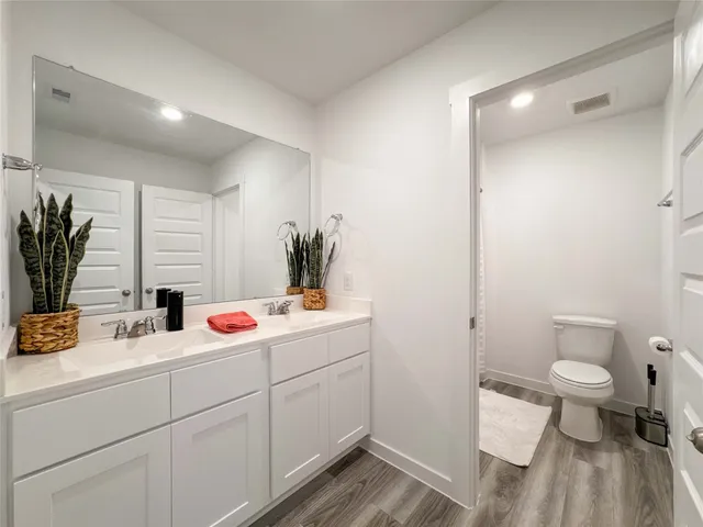 a bathroom with a sink and mirror with toilet