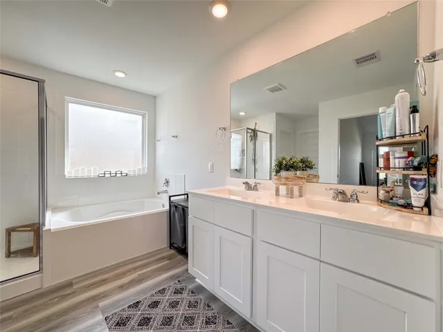 a bathroom with a tub sink and mirror