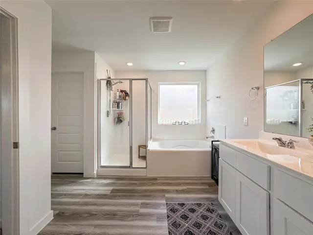 a bathroom with a tub sink and mirror