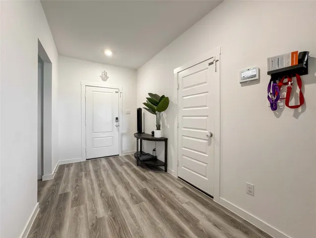 a view of a hallway with wooden floor and closet