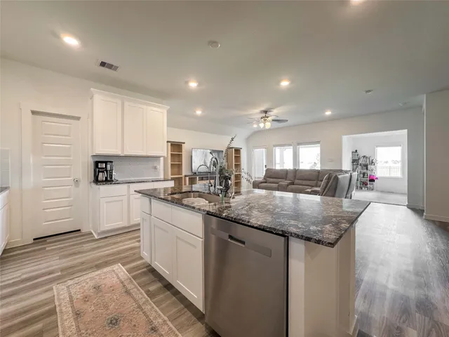 a kitchen with stainless steel appliances granite countertop a sink and cabinets