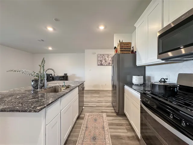 a kitchen with granite countertop a sink and a stove top oven
