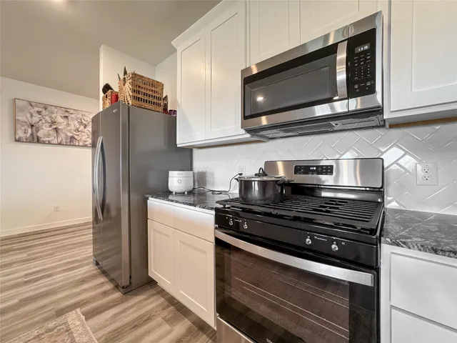 a kitchen with stainless steel appliances granite countertop a stove and a microwave