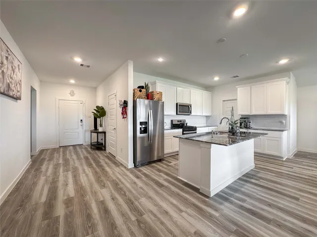 a kitchen with refrigerator and cabinets