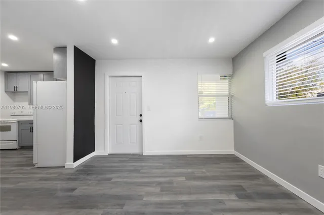 a view of empty room with wooden floor and window