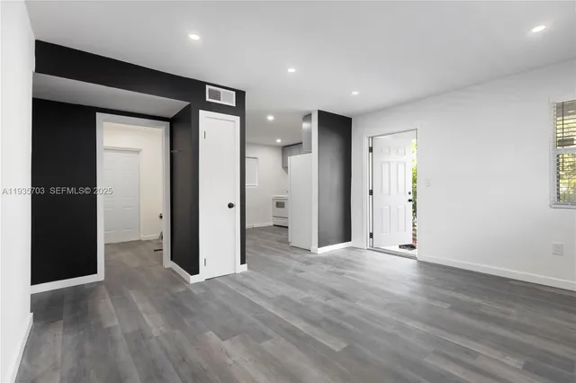 a view of an empty room with wooden floor