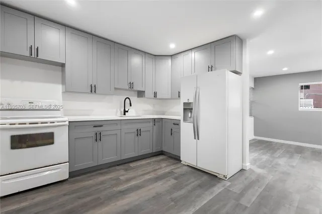 a kitchen with white cabinets and white appliances