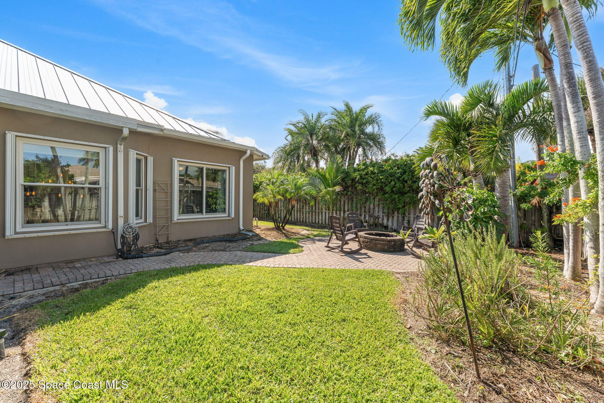 162 Miami Avenue Indialantic, FL 32903 - Photo 42 of 49 a view of a backyard with plants and palm tree