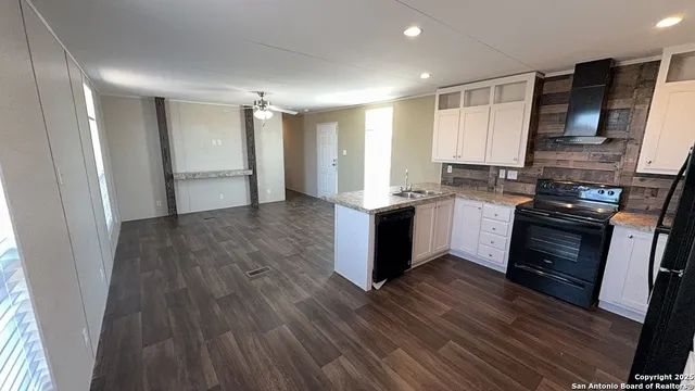 a kitchen with a sink wooden floor and stainless steel appliances