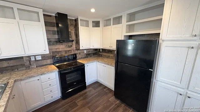 a kitchen with a refrigerator and a stove top oven