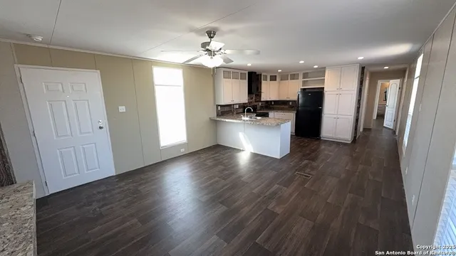 a view of a living room and kitchen with wooden floor