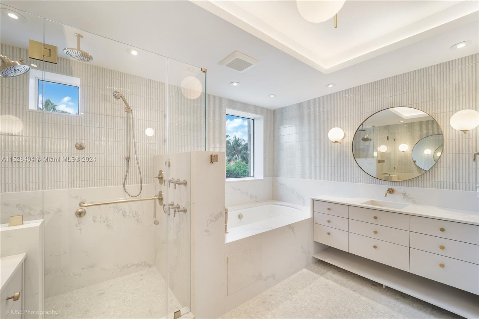 Lake Villa Key Biscayne, FL 33149 - Photo 18 of 51 a spacious bathroom with a tub shower and mirror