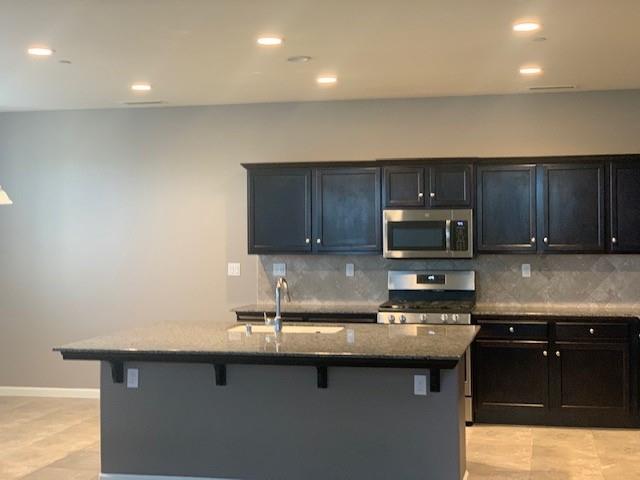 2205 Lombard Lane Clovis, CA 93619 - Photo 2 of 13 a kitchen with a sink a microwave and cabinets
