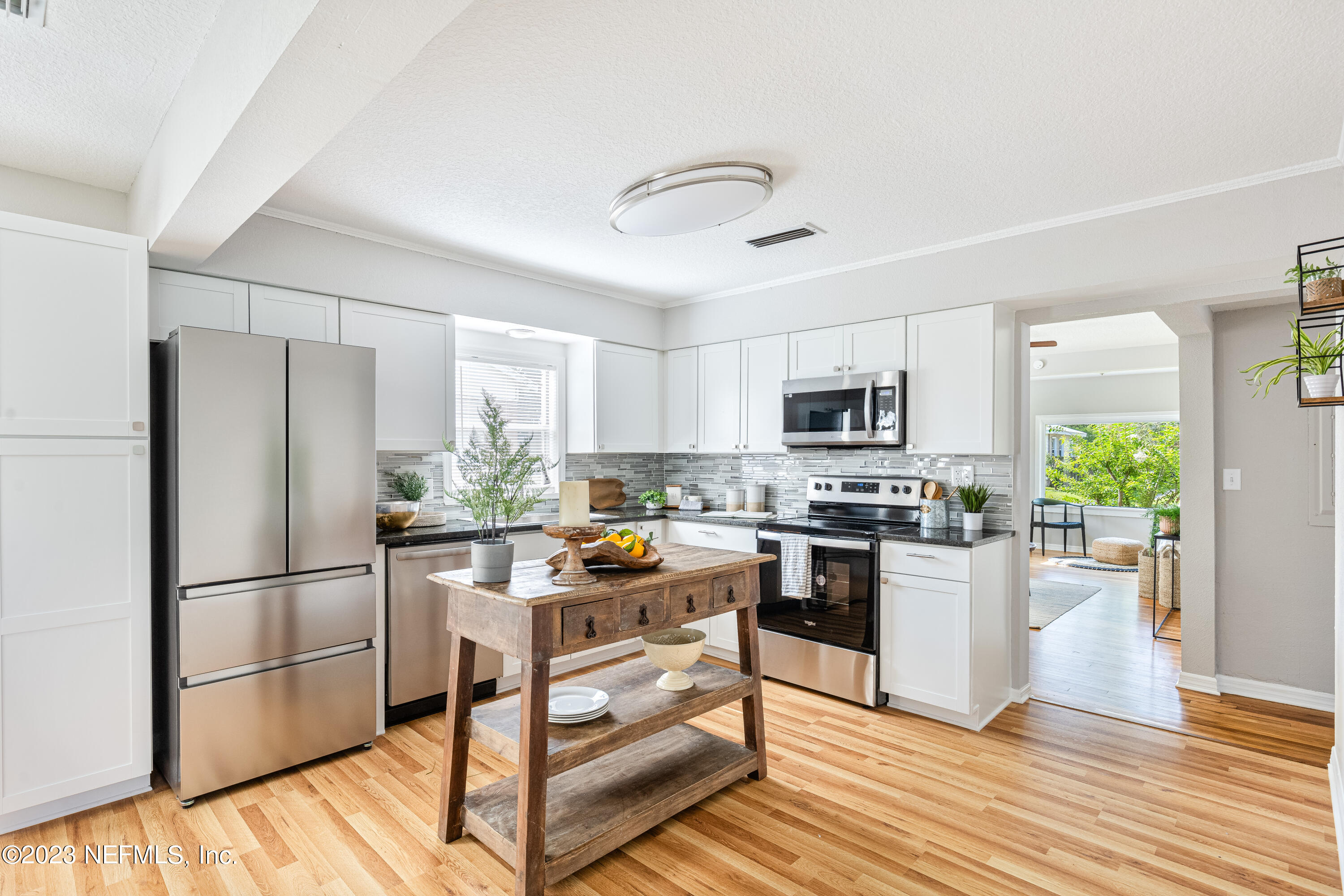 a kitchen with stainless steel appliances granite countertop a refrigerator stove microwave and sink