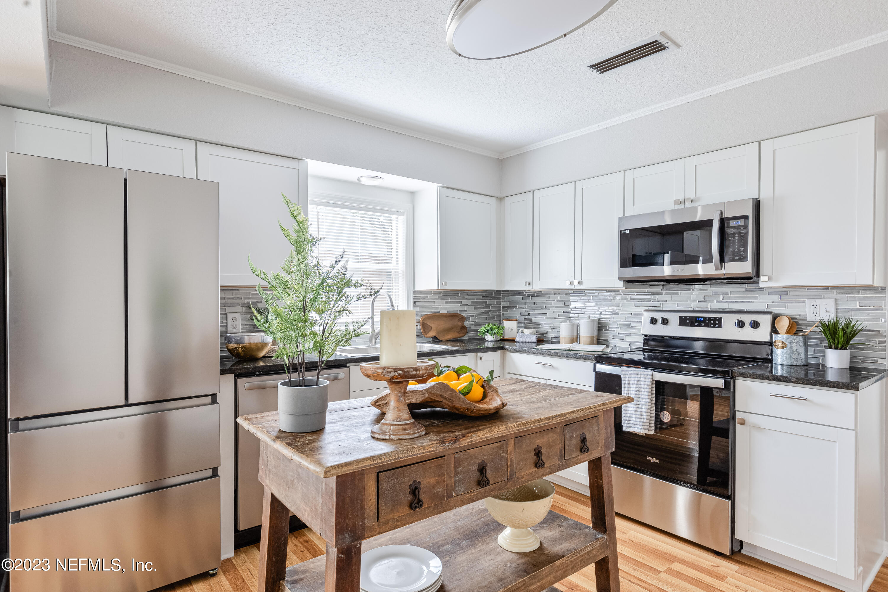 4729 Cambridge Road Jacksonville, FL 32210 - Photo 14 of 37 a kitchen with stainless steel appliances a stove refrigerator sink and microwave