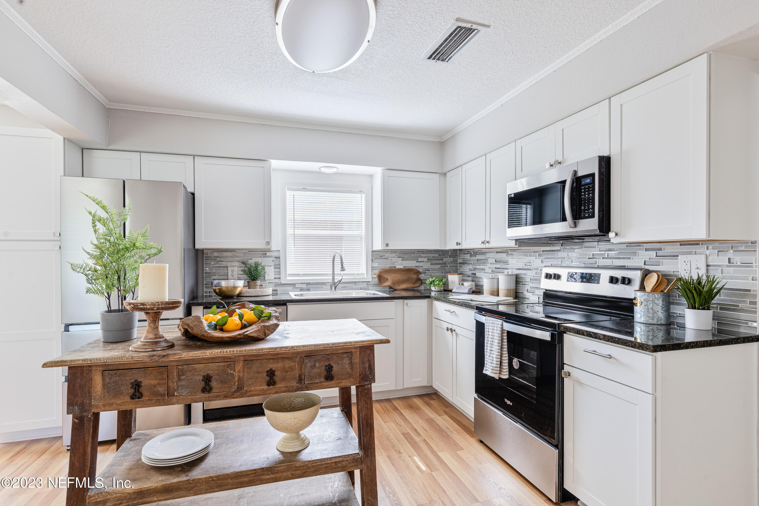 4729 Cambridge Road Jacksonville, FL 32210 - Photo 15 of 37 a kitchen with a sink a stove and cabinets