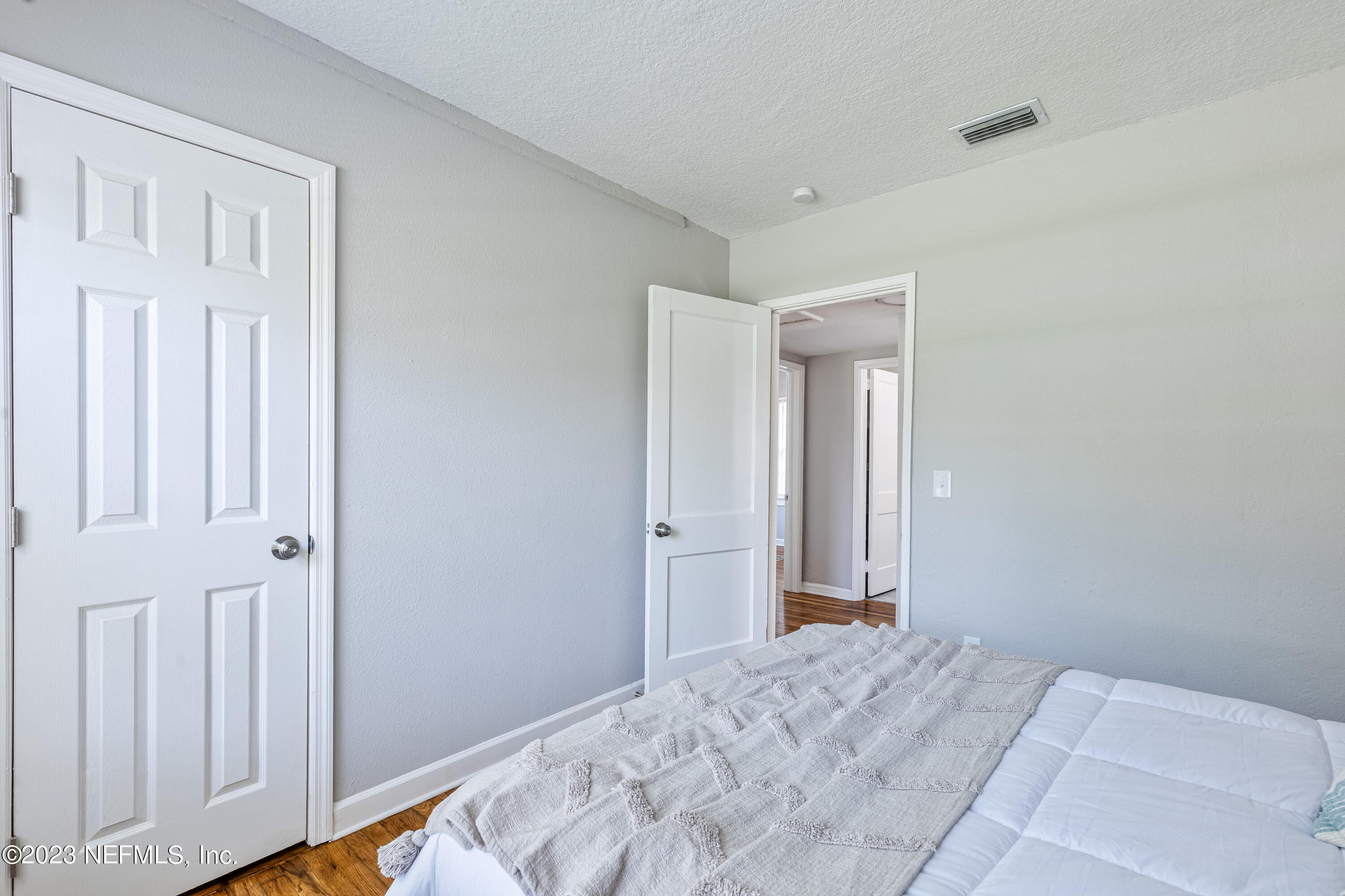 4729 Cambridge Road Jacksonville, FL 32210 - Photo 29 of 37 a bedroom with a bed and wooden floor