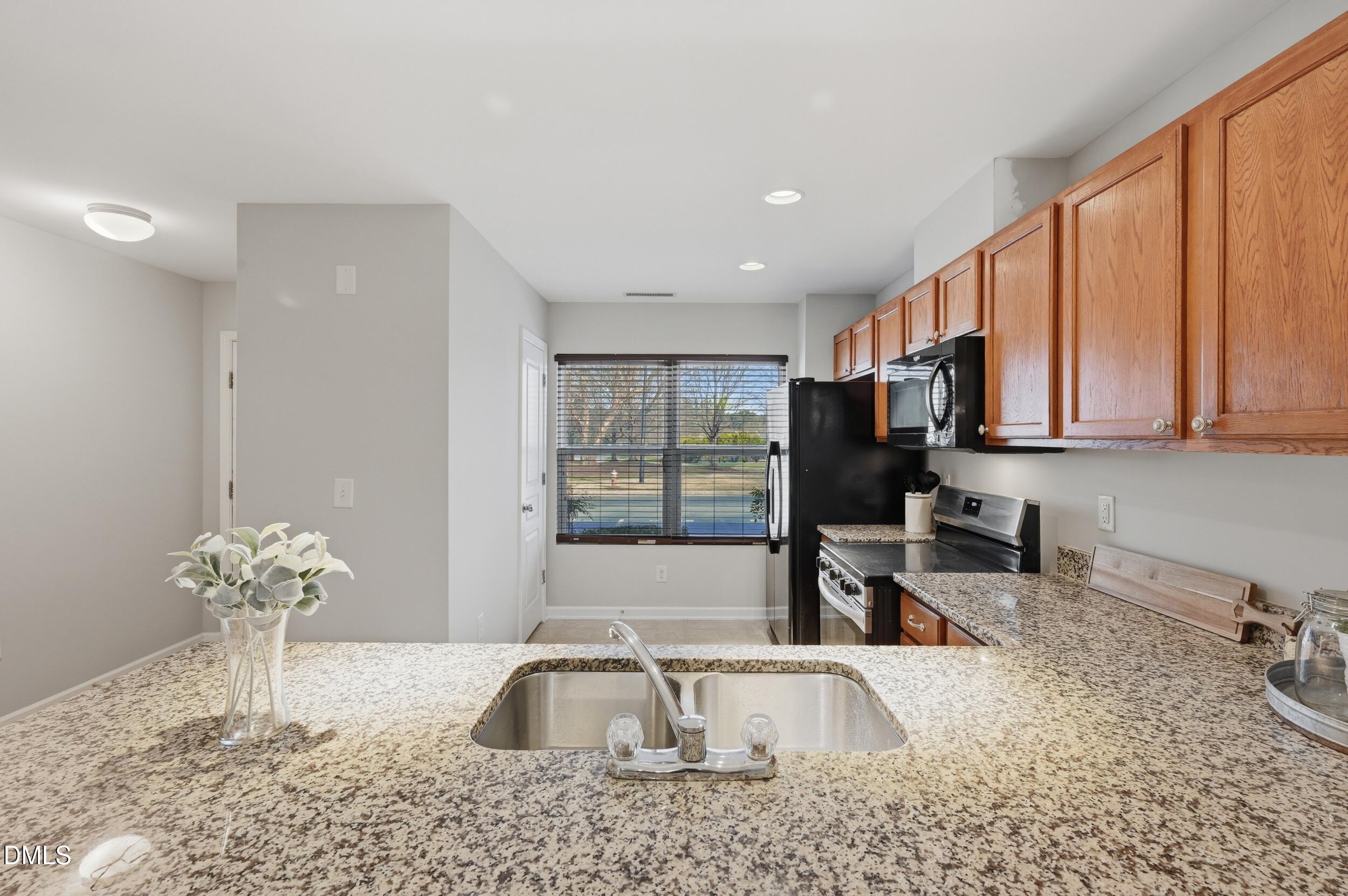 2907 Berkeley Springs Place Raleigh, NC 27616 - Photo 10 of 32 a view of kitchen island with stainless steel appliances granite countertop sink and cabinets