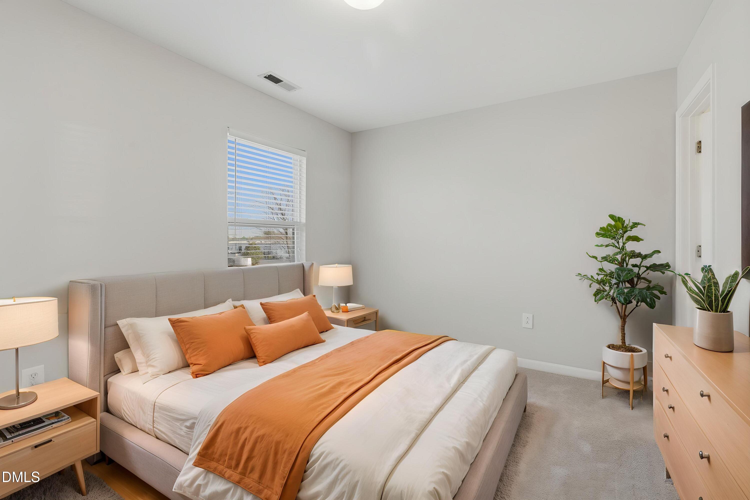 2907 Berkeley Springs Place Raleigh, NC 27616 - Photo 17 of 32 a bedroom with a bed and a potted plant