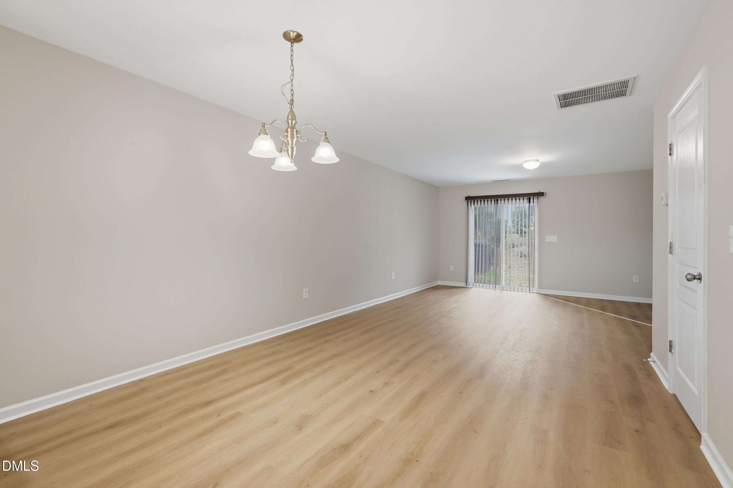 2907 Berkeley Springs Place Raleigh, NC 27616 - Photo 4 of 32 a view of a room with wooden floor and windows