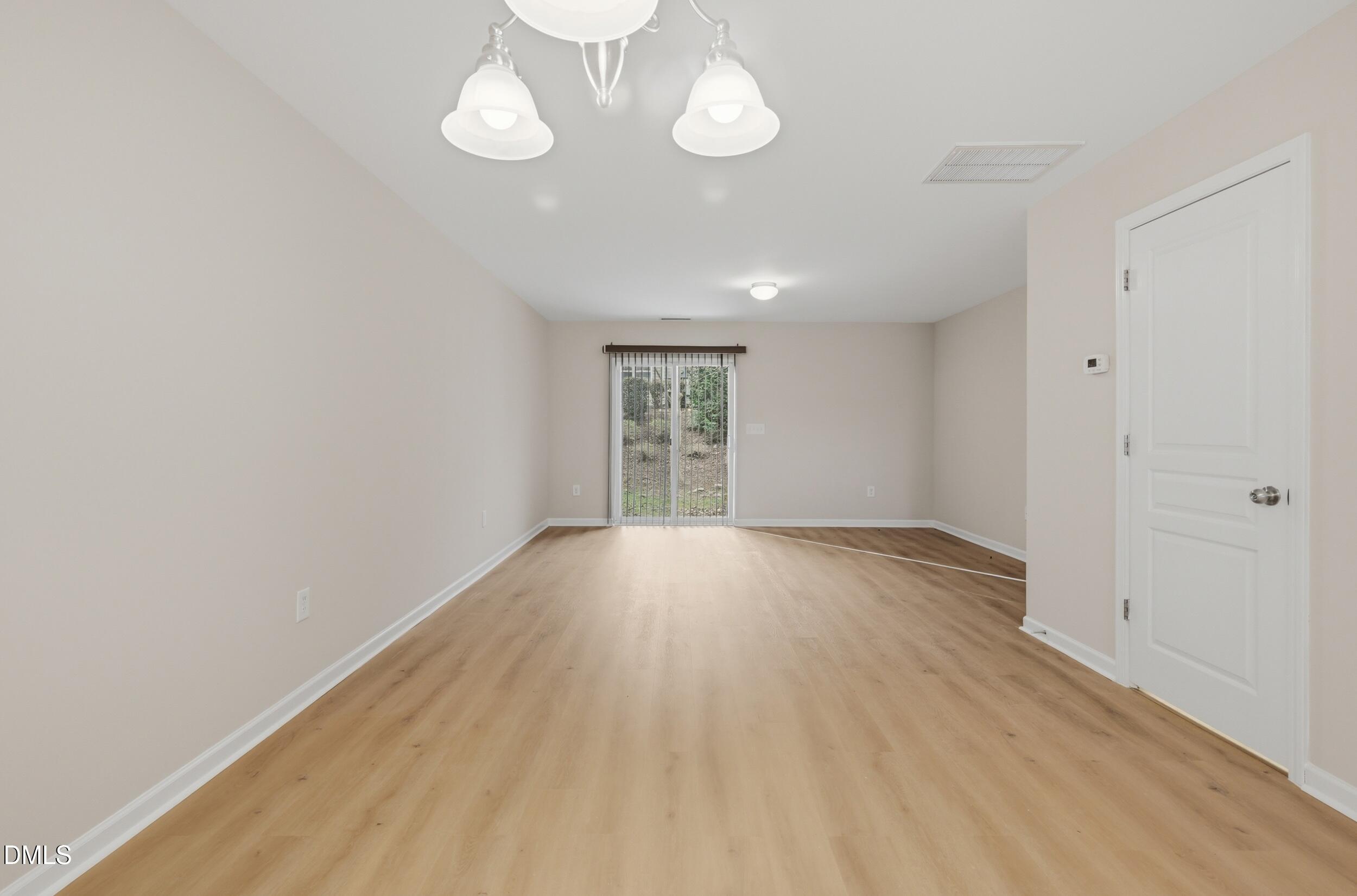 2907 Berkeley Springs Place Raleigh, NC 27616 - Photo 7 of 32 an empty room with wooden floor and windows