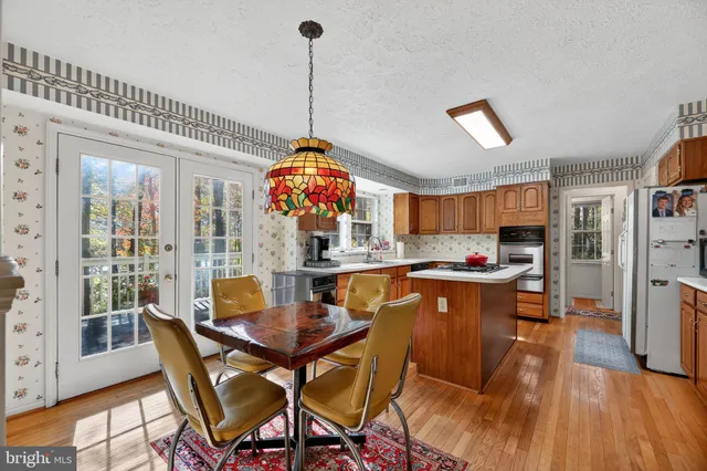 a view of a dining room and livingroom with furniture wooden floor a chandelier