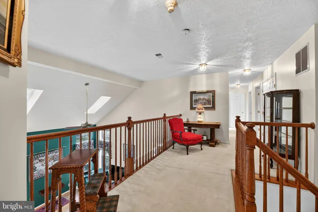 a view of a hallway with furniture and windows