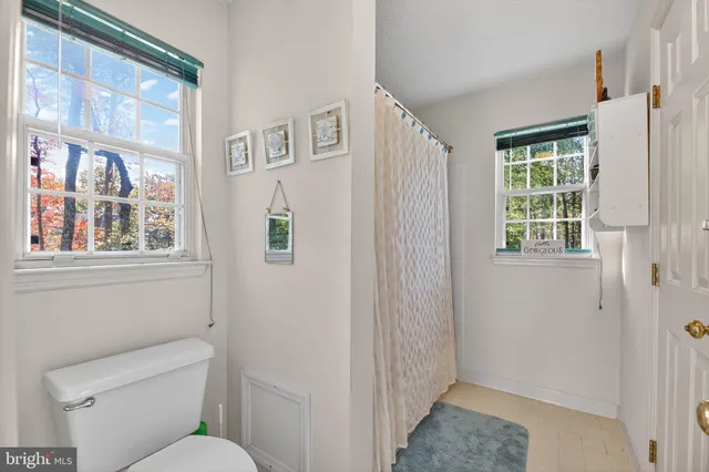 a bathroom with a toilet and a shower