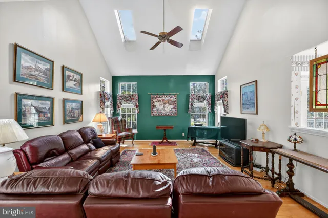 a living room with furniture a window and a ceiling fan