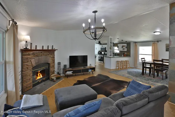 a living room with furniture a dining table and a fireplace