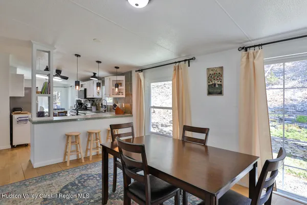 a kitchen with stainless steel appliances granite countertop a stove a refrigerator a dining table and chairs with wooden floor