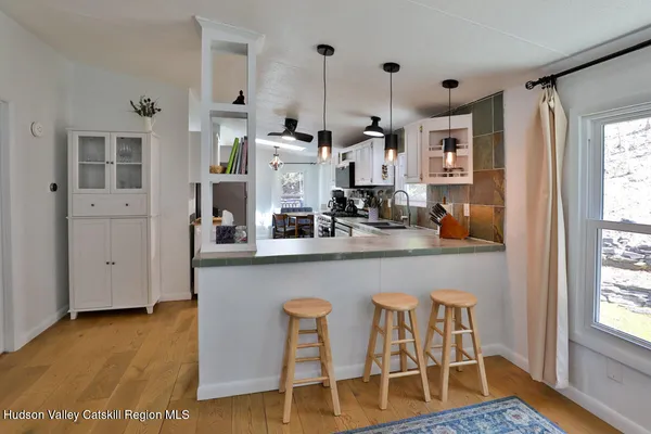 a kitchen with stainless steel appliances a dining table chairs and wooden floor