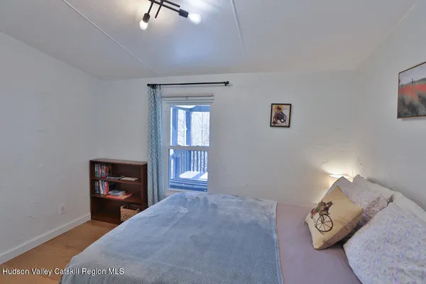 a bedroom with a bed and wooden floor