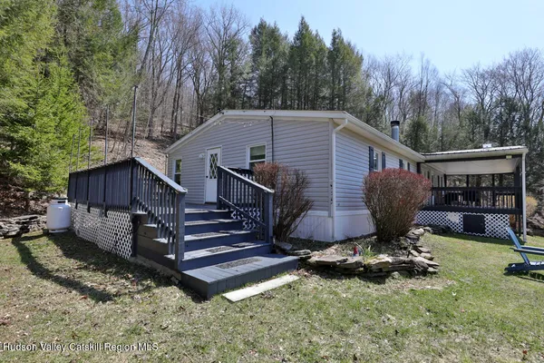 a view of backyard with wooden fence and a large tree