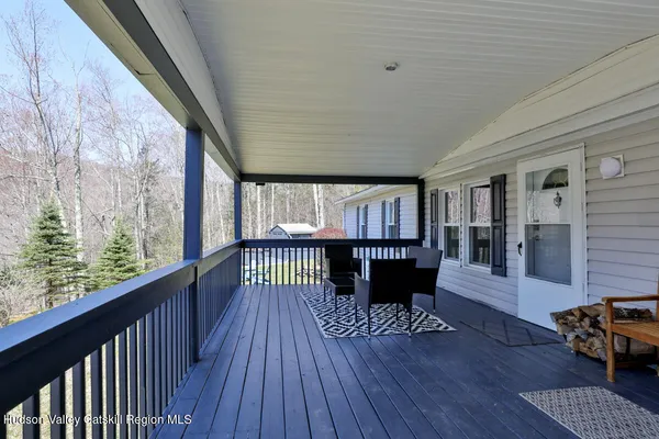 a view of a porch with furniture and wooden floor