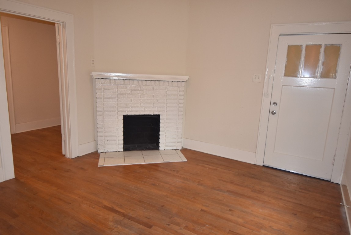4618 Clay Street Houston, TX 77023 - Photo 10 of 20 a view of an empty room with wooden floor and a fireplace
