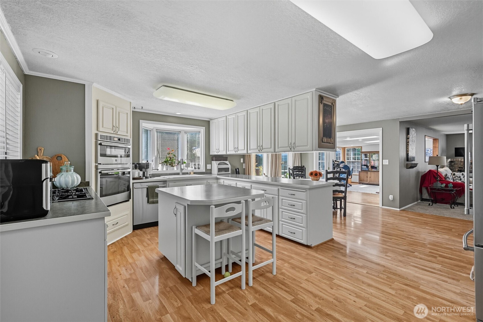 1125 Lattimore Road Ferndale, WA 98248 - Photo 11 of 39 a kitchen with white cabinets and chairs