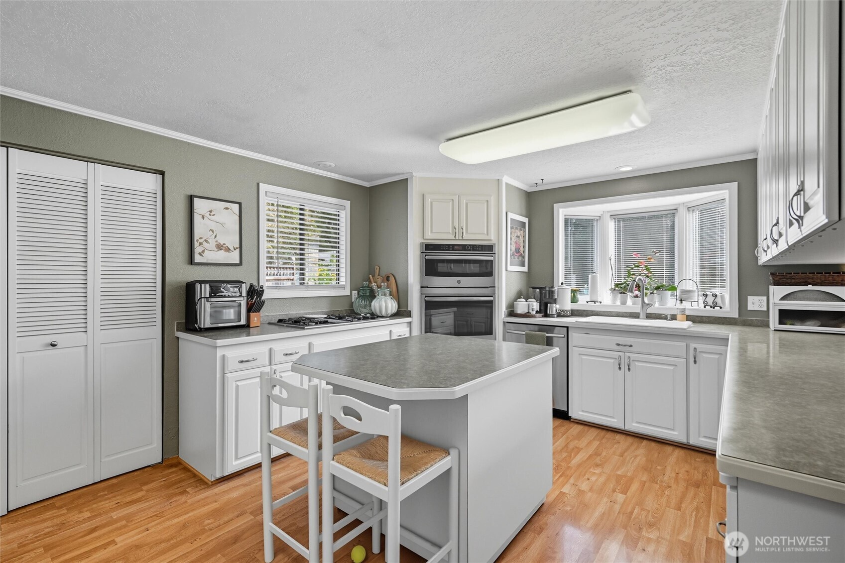 1125 Lattimore Road Ferndale, WA 98248 - Photo 10 of 39 a kitchen with stainless steel appliances granite countertop a stove top oven a sink dishwasher a dining table and chairs with wooden floor