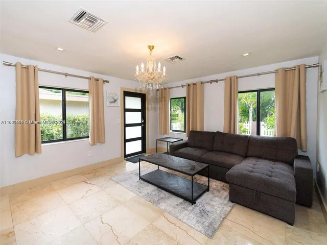 a living room with furniture and a chandelier