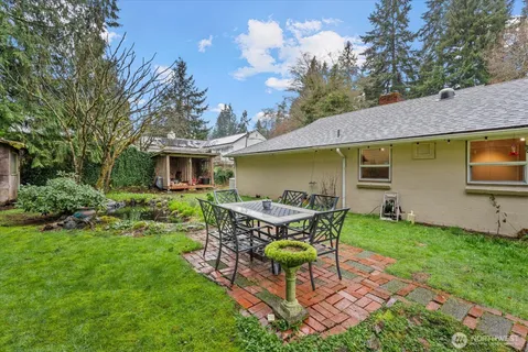 a view of a house with backyard and sitting area