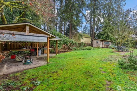 a view of a chair and table in backyard of the house