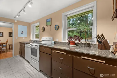 a kitchen with stainless steel appliances granite countertop a sink and a large window