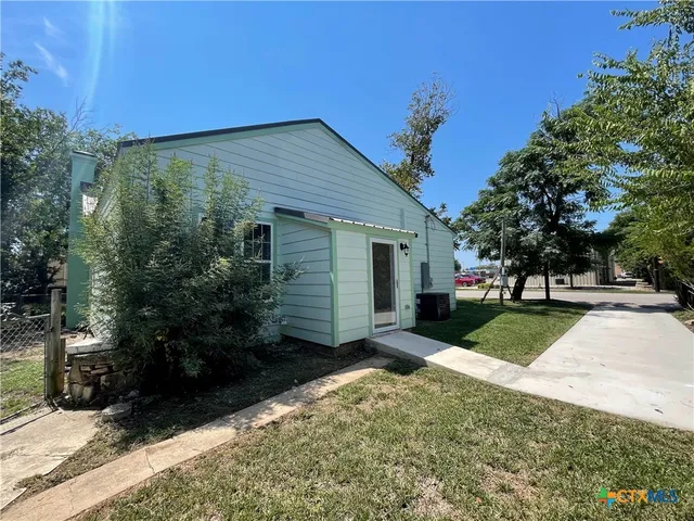 a view of a house with backyard and tree