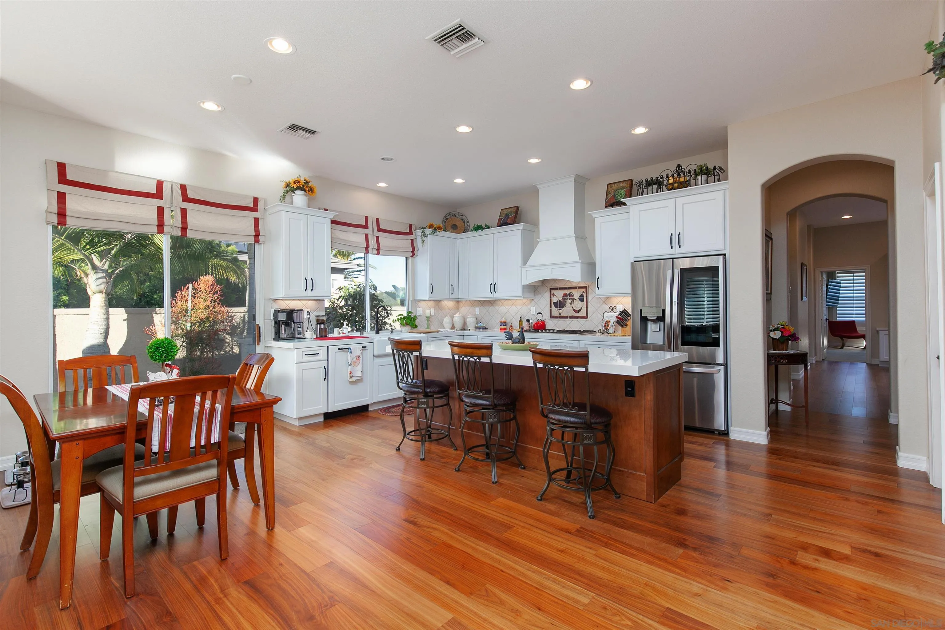 11760 Treadwell Drive Poway, CA 92064 - Photo 16 of 52 a kitchen with stainless steel appliances granite countertop a dining table chairs refrigerator sink and cabinets