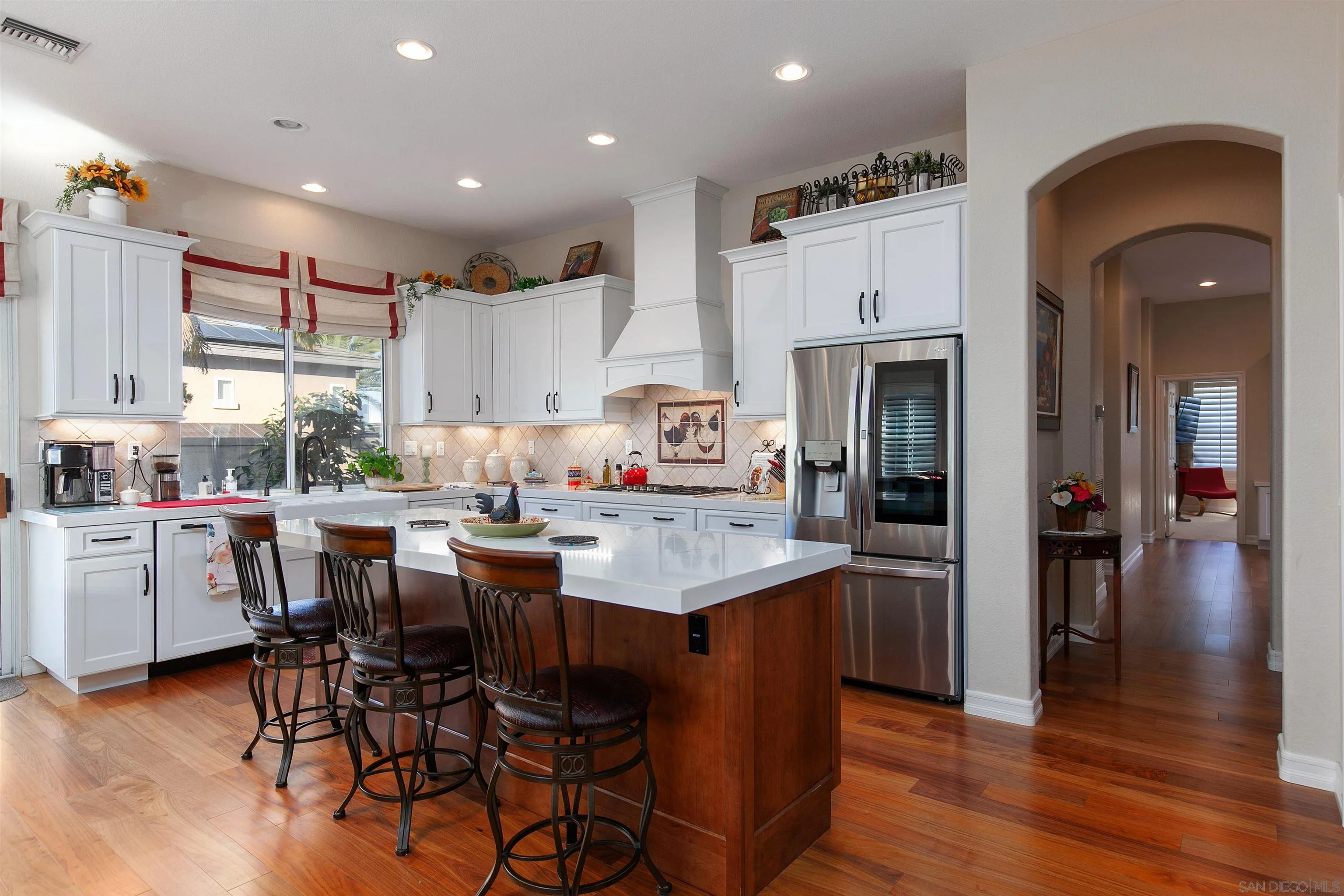 11760 Treadwell Drive Poway, CA 92064 - Photo 17 of 52 a kitchen with stainless steel appliances kitchen island granite countertop a table chairs and a refrigerator