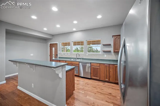 a kitchen with stainless steel appliances granite countertop refrigerator sink and microwave