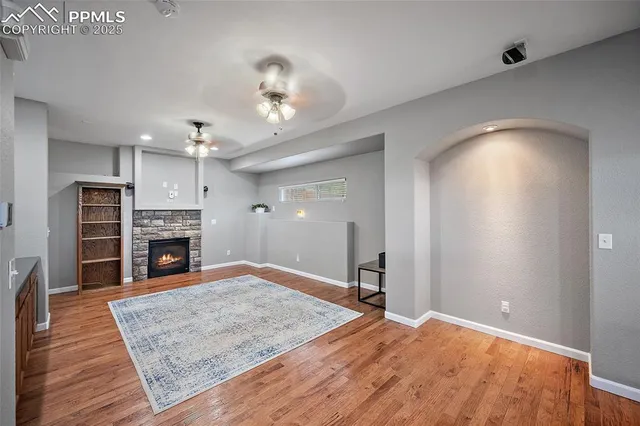 a view of a livingroom with a fireplace a chandelier and wooden floor